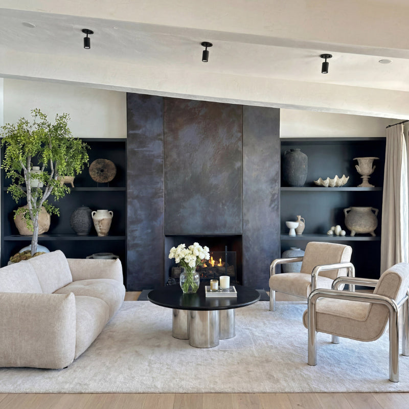 Modern living room with a fireplace, shelves, and decorative items.