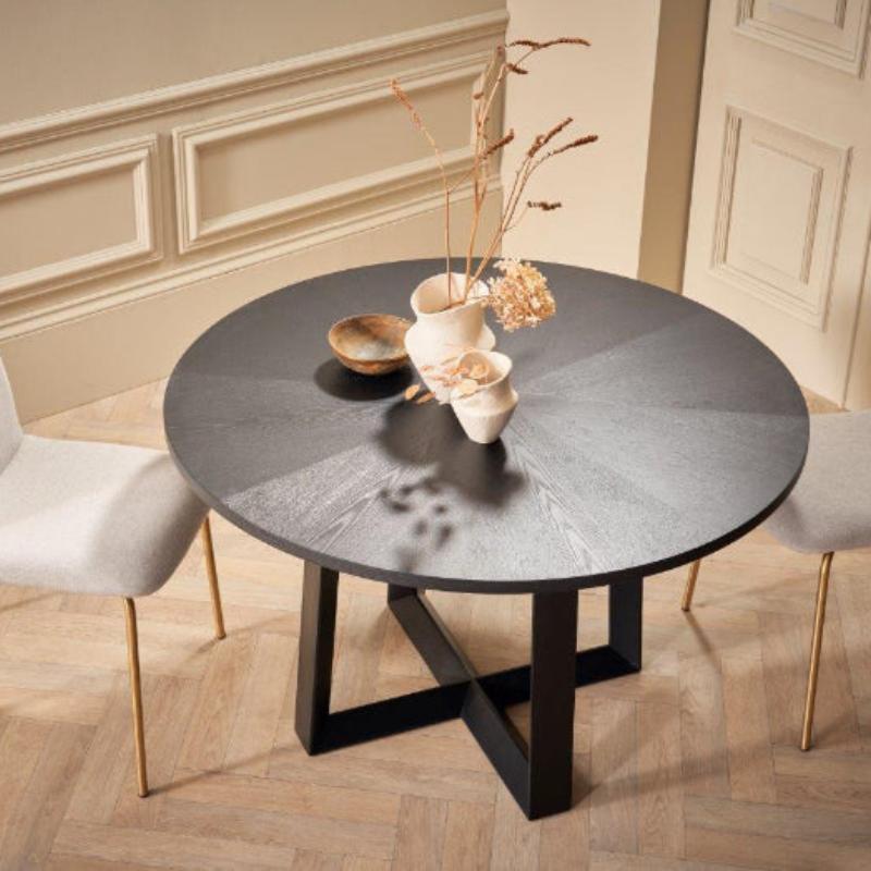 Round dining table with two chairs in a room with decorative wall molding.