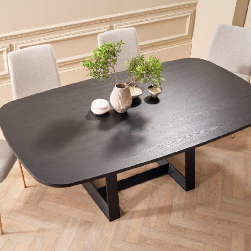 Dining table with four chairs in a room with decorative wall molding.