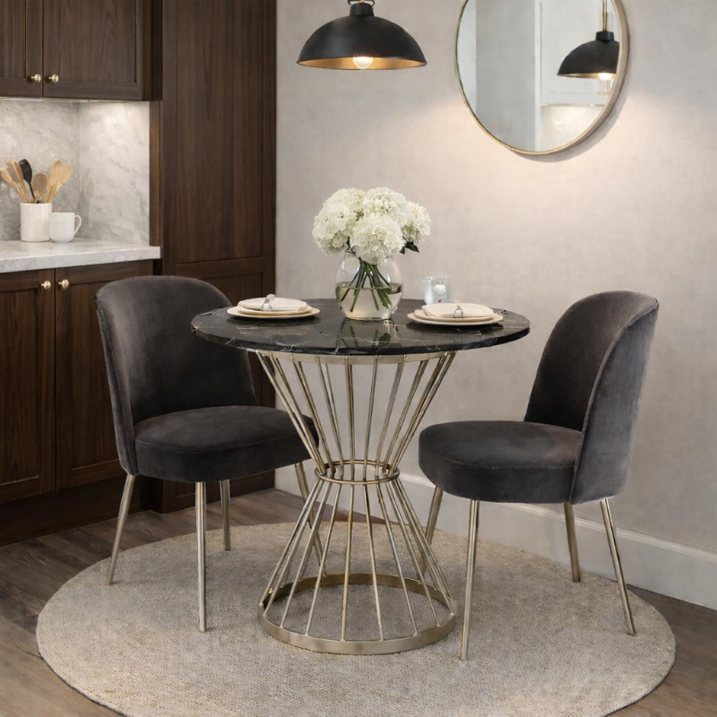 Dining area with a round table and two chairs in a kitchen setting.