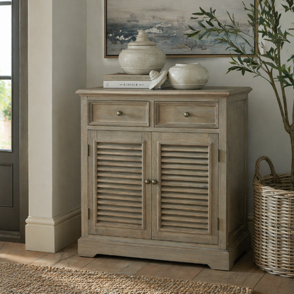 Wooden cabinet with louvered doors in a room with a plant and framed picture.