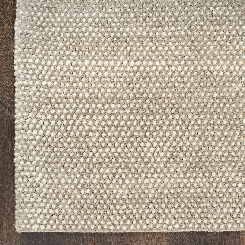 Textured grey ivory rug on a wooden floor