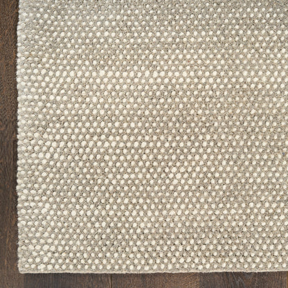 Textured grey ivory rug on a wooden floor