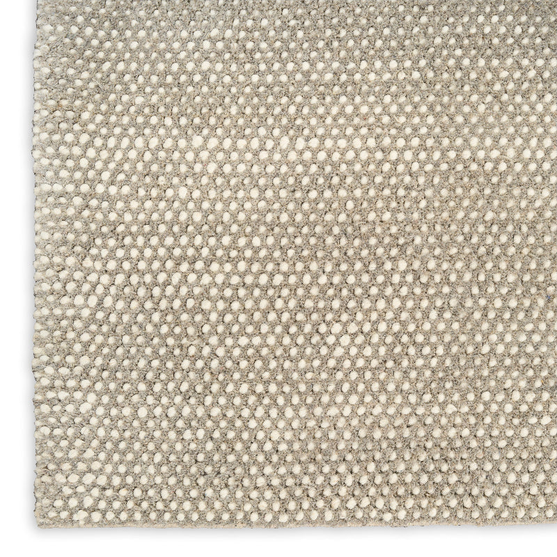 Close-up of a textured beige fabric with a subtle pattern on a white background