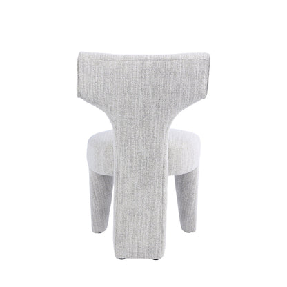 A modern sculptural upholstered chair in a light gray textured fabric, shown from the back against a plain white background.