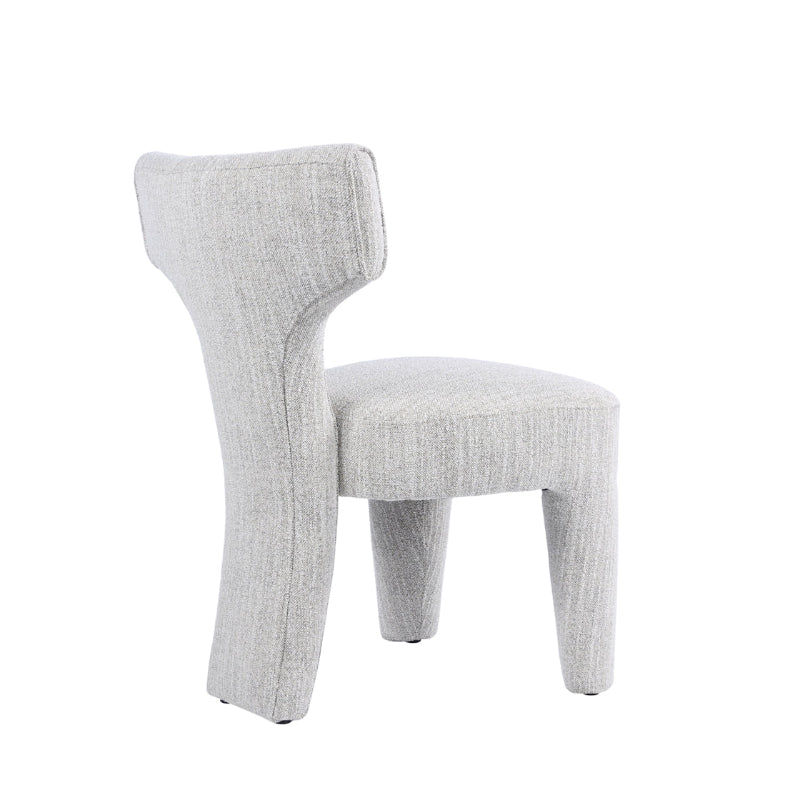 A light gray upholstered accent chair with a sculptural, curved backrest and tapered legs, shown against a plain white background.