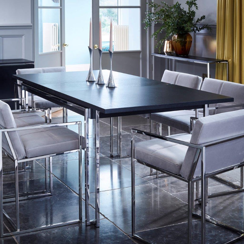 Modern dining room with a black table and gray chairs in a well-lit room.