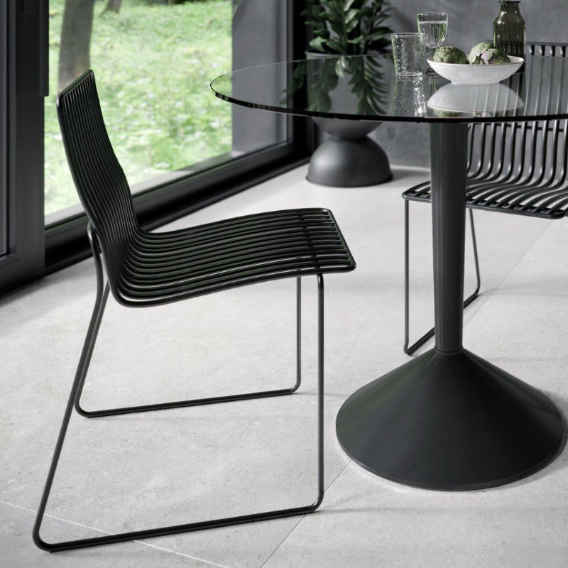 Modern black chairs and table in a room with large windows.