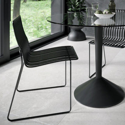 Modern black chairs and table in a room with large windows.