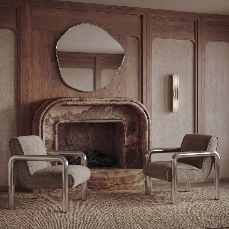 Two armchairs in a room with a rustic fireplace and wooden paneling.