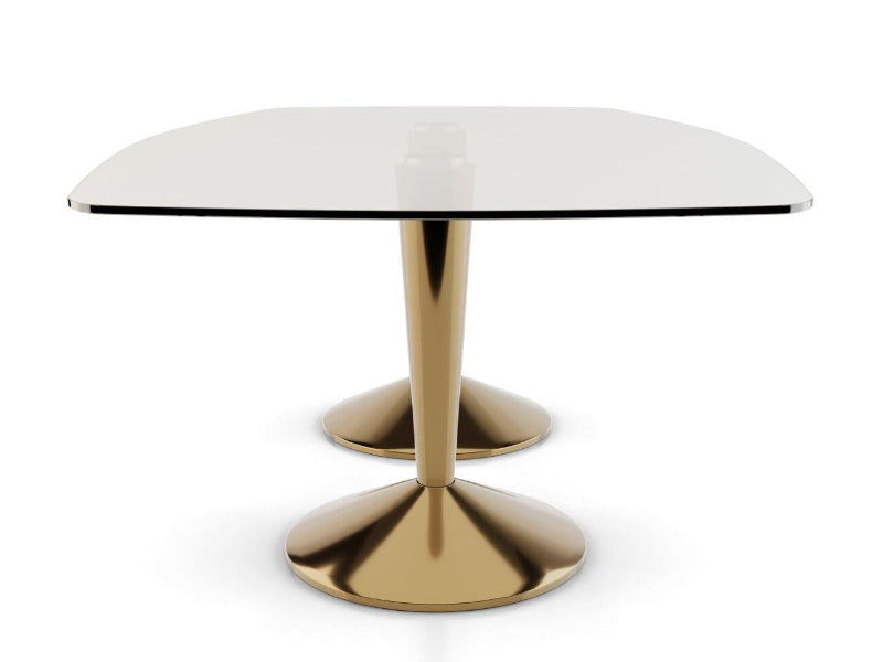 Dining table with a glass top and gold metal base on a white background