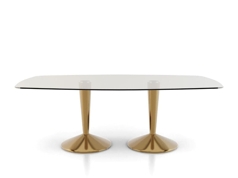 Dining table with glass top and gold metal legs on a white background
