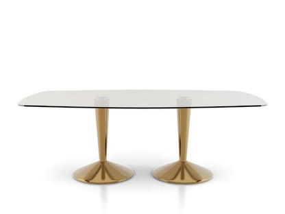 Dining table with glass top and gold metal legs on a white background