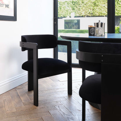 Black chairs around a dining table in a room with a window view