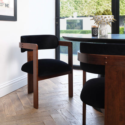 Dining room with wooden chairs and a round table near a window.