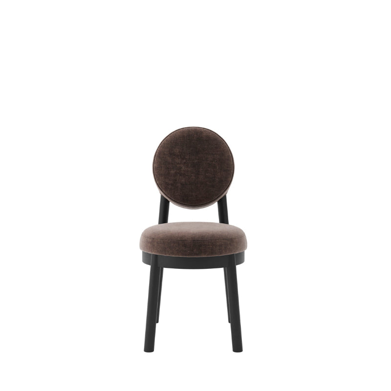 A modern dining chair with a round upholstered backrest and seat cushion in a dark brown velvet fabric, supported by a black metal frame, shown against a plain white background.