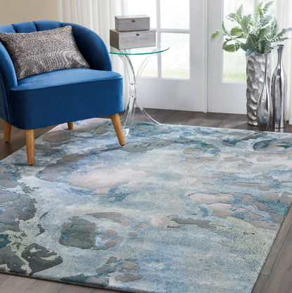 Blue armchair with a floral-patterned rug in a living room setting.