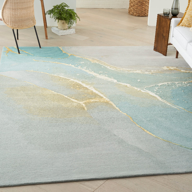 Gradient rug with gold accents on a wooden floor in a living room setting.