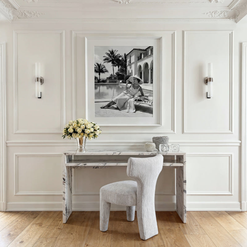 Modern interior with a marble desk, chair, and wall art in a stylish room.