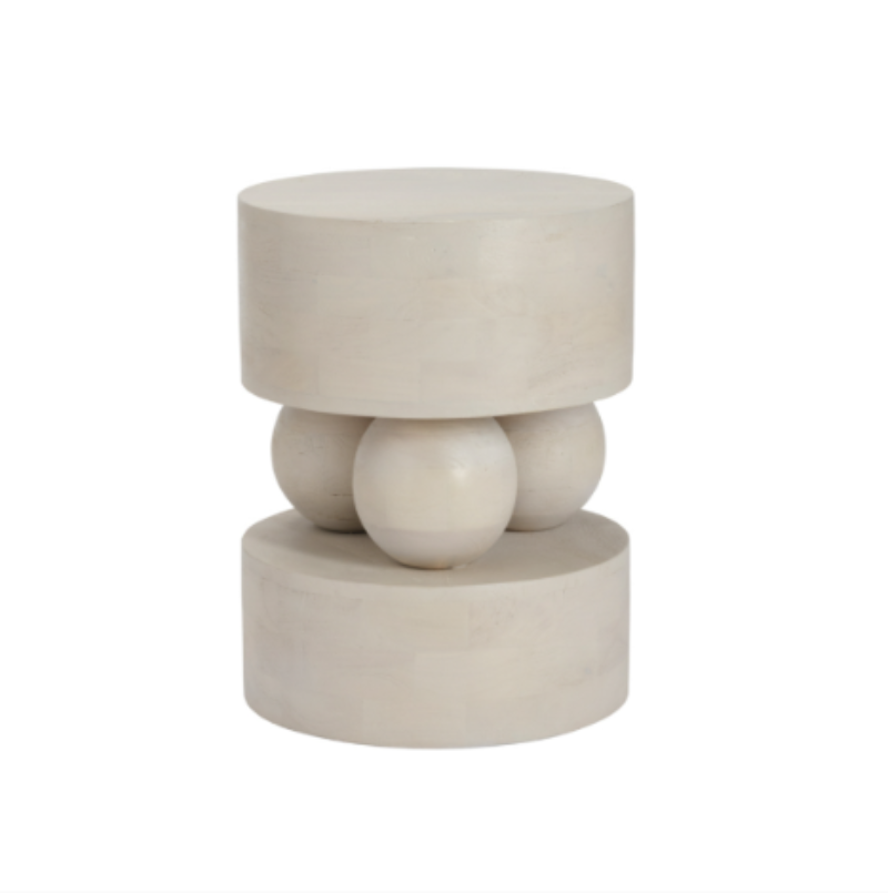 A modern sculptural side table or stool made of a light beige stone or concrete, featuring a top cylindrical platform supported by three rounded spherical forms in the middle, and a wider cylindrical base below, set against a plain white background.