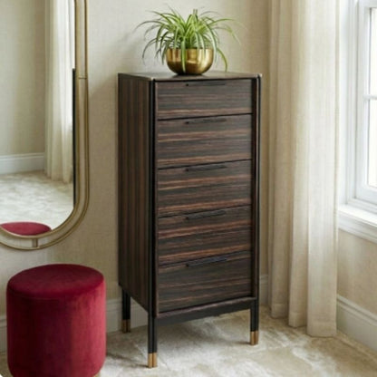 Wooden chest of drawers with a plant on top in a room with a mirror and red stool.