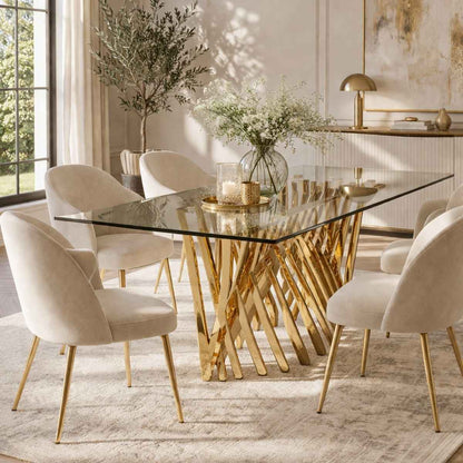 Dining room with a glass table and gold legs, surrounded by beige chairs.