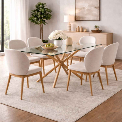 Dining room with a glass table and white chairs on a light rug.