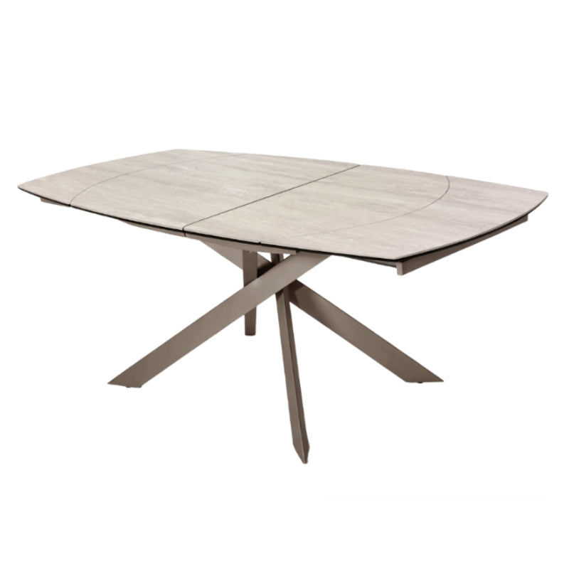 A modern rectangular extendable dining table with a light gray wood-grain top and a sculptural X-shaped metal base in a warm taupe finish, shown on a solid white background.