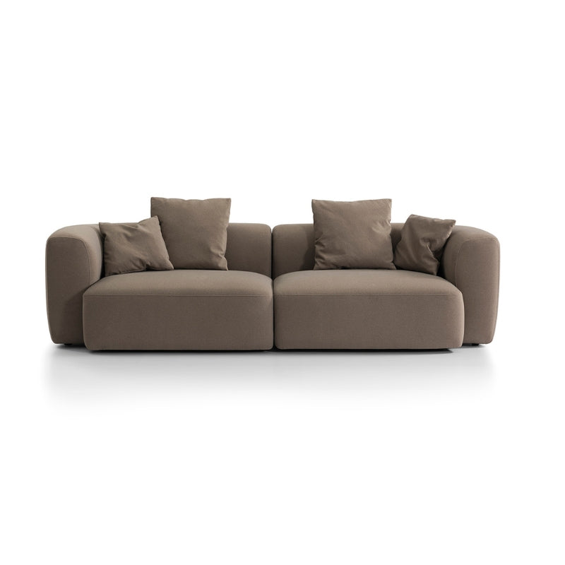 Low profile brown Sofa with four cushions on a white background