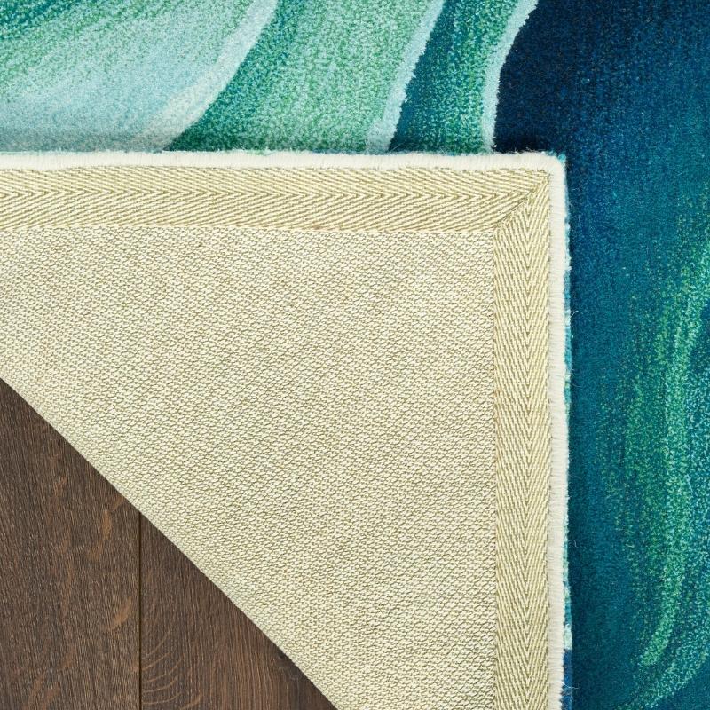 Close-up of a textured rug corner with green, beige, and blue colors.