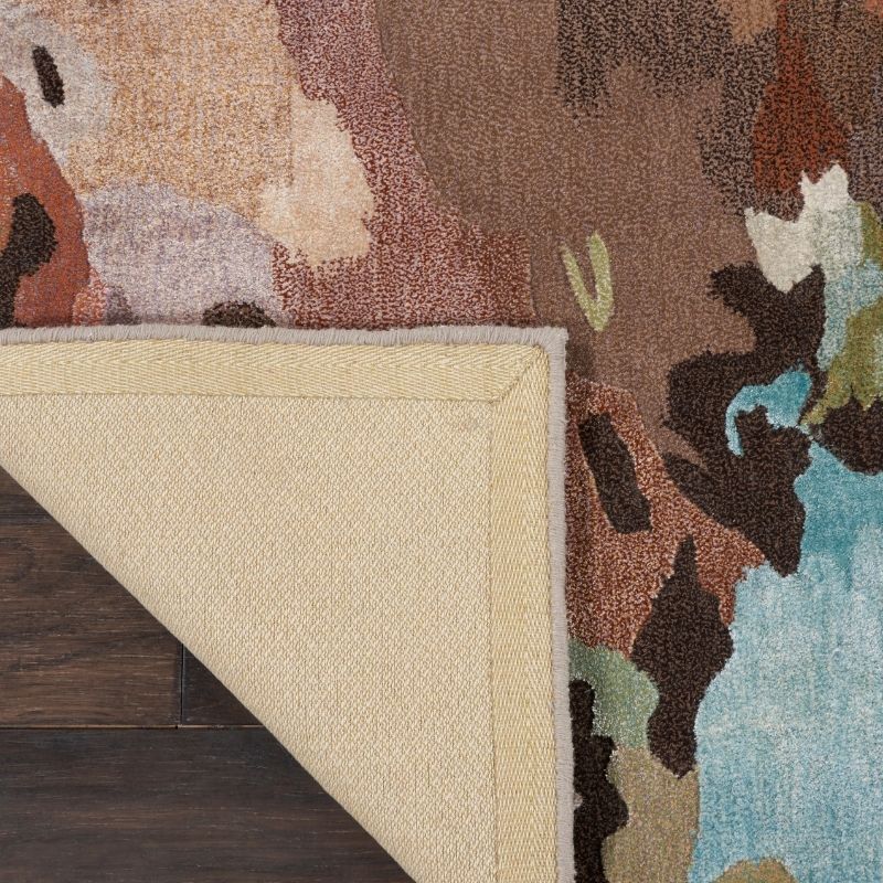 Multicolored area rug with a textured border on a wooden floor.