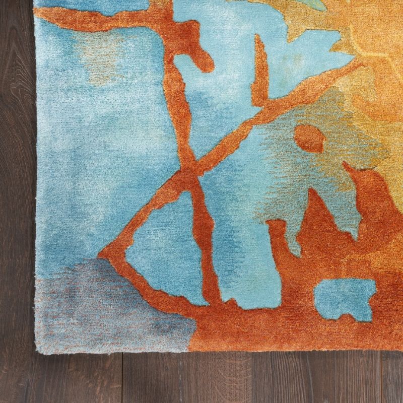 Colorful abstract rug with orange and blue patterns on a wooden floor.
