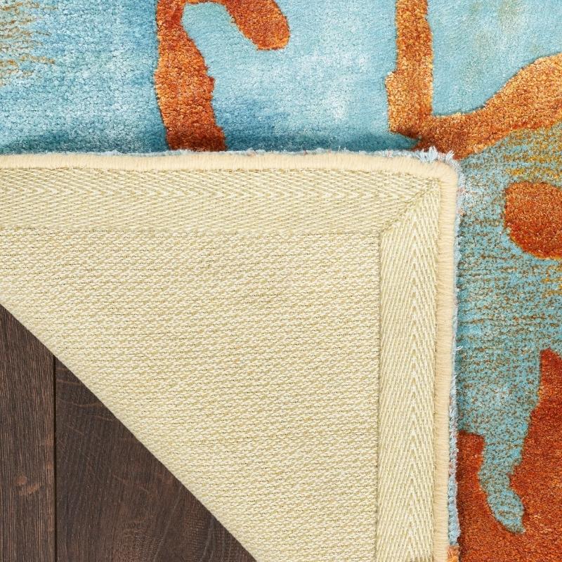 Close-up of a multicolored rug with geometric patterns on a wooden floor.