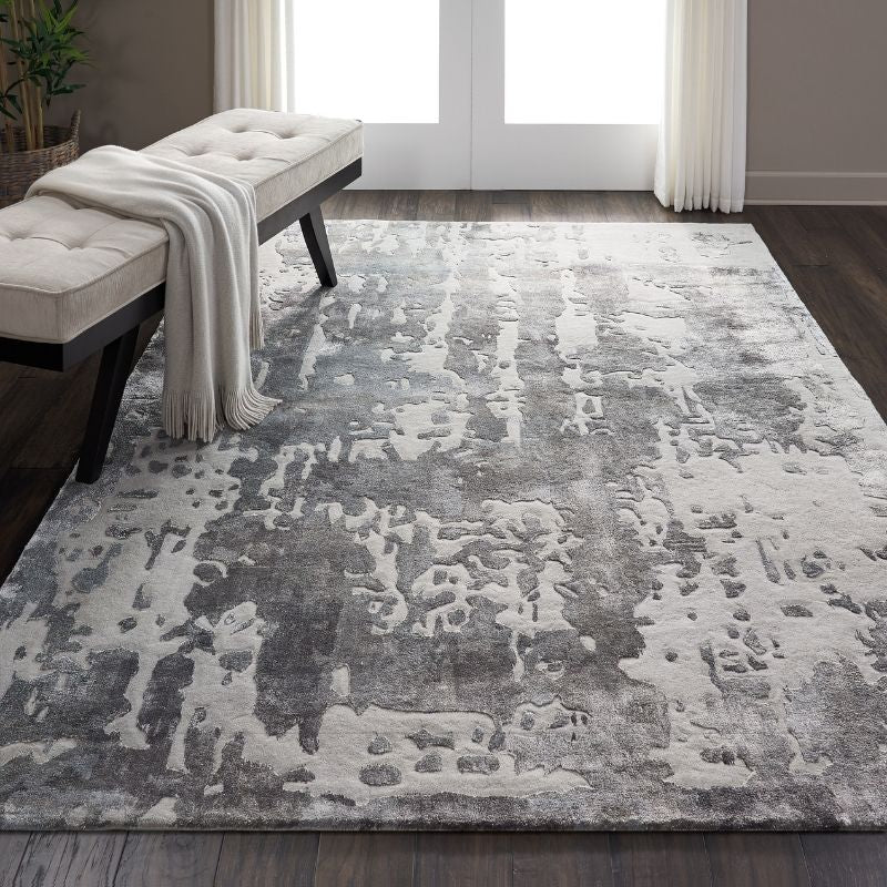 Gray and white textured area rug in a room with a bench and curtains.
