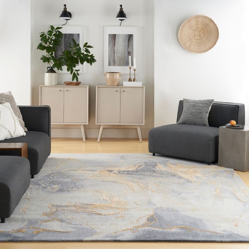 Modern living room with gray sofa, rug, and decorative items.