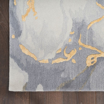 Gray and gold abstract patterned rug on a wooden floor