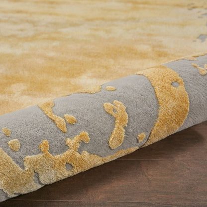 Close-up of a textured rug with yellow and gray pattern on a wooden floor.