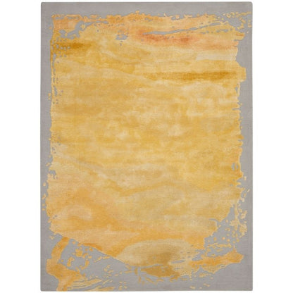 A rectangular area rug with a textured abstract design, featuring a large central golden-yellow watercolor-like wash bordered by a gray background with subtle orange and yellow accents.