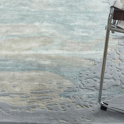 Close-up of a textured gray rug with a chair leg partially visible