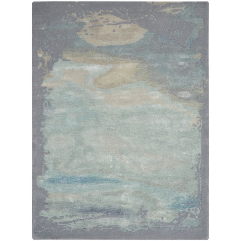 An abstract area rug with a distressed, painterly design in muted shades of gray, teal, beige, and blue, shown flat against a white background.