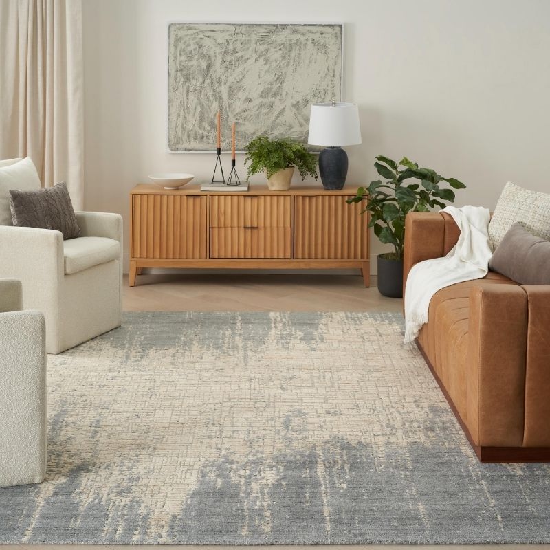 Living room with a brown sofa, beige armchair, wooden sideboard, and decorative elements.