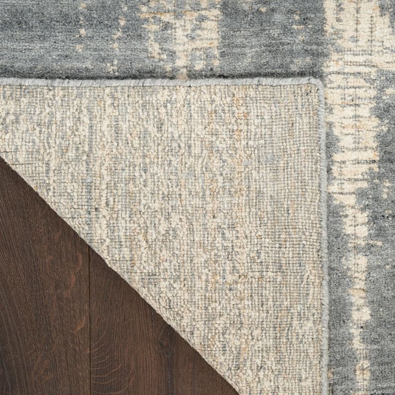 Close-up of a textured rug with a geometric pattern on a wooden floor.