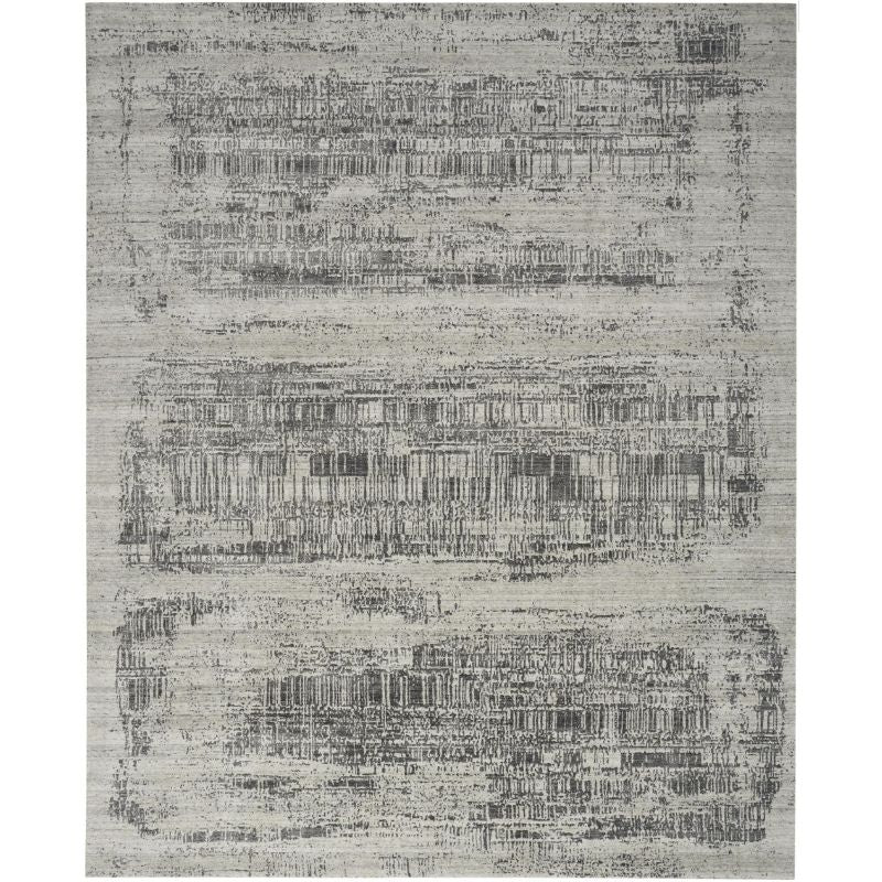 A rectangular area rug with a distressed, abstract pattern in shades of gray, beige, and off-white.