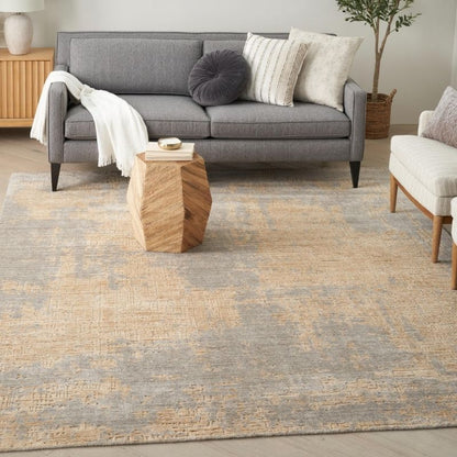 Living room with a gray sofa, wooden side table, and patterned rug.