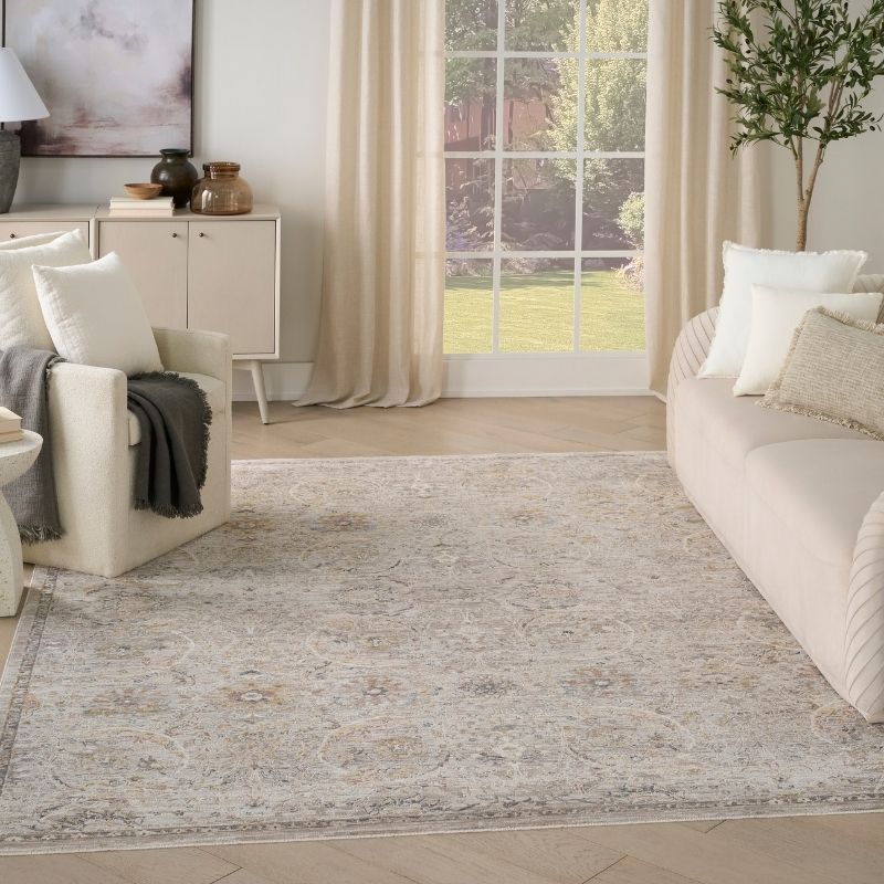 Living room with a large area rug, white furniture, and a large window.