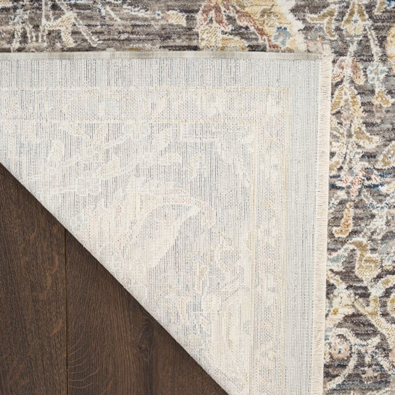 Close-up of a rug with a geometric pattern on a wooden floor.