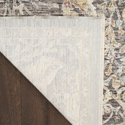 Close-up of a rug with a geometric pattern on a wooden floor.