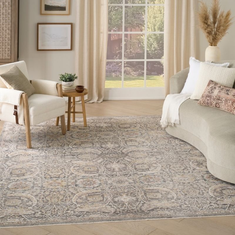 Living room with a patterned rug, sofa, armchair, and decorative elements.