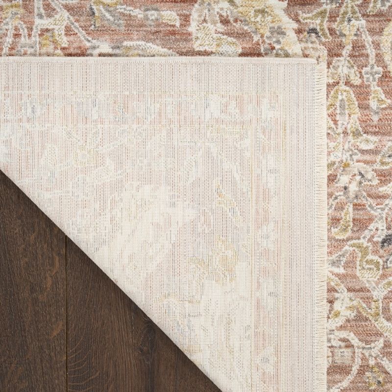 Close-up of a patterned rug with a neutral color scheme on a wooden floor.
