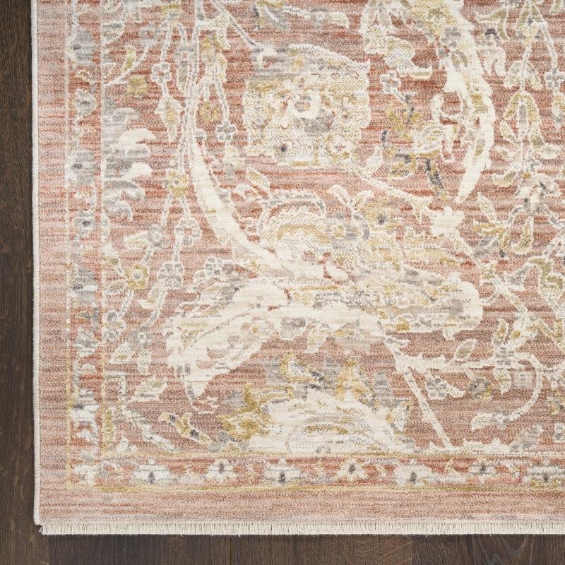 Close-up of a patterned rug with a neutral color palette on a wooden floor.